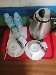 a red tray with a tea pot and plates and water at Sang Yoo Mountain View Tagaytay Bed and Breakfast - Taal Lake View in Tagaytay +37 photos