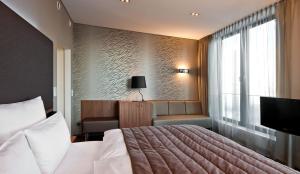 a bedroom with a bed and a chair and a window at COSMO Hotel Berlin Mitte in Berlin +37 photos