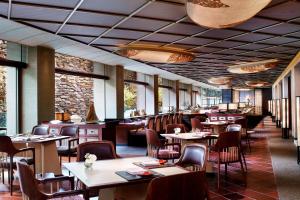 a dining room with tables and chairs and windows at The Ritz-Carlton Kyoto in Kyoto