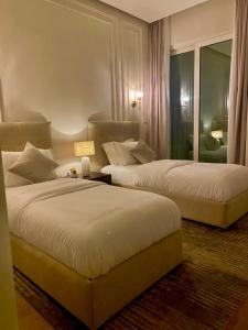 En eller flere senge i et værelse på Beachfront Luxury Apartment-Pearl Island شقه مطله على الشاطئ بجزيرة اللؤلؤه + 32 billeder