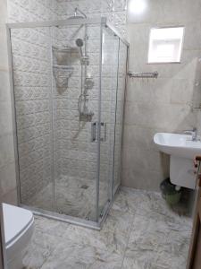 eine Duschkabine im Bad mit WC und Waschbecken in der Unterkunft Riverfront Chalet Gabala in Qəbələ