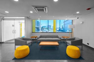 ein Wartezimmer mit Sofas, einem Tisch und Stühlen in der Unterkunft City Express by Marriott Ciudad Juárez in Ciudad Juárez