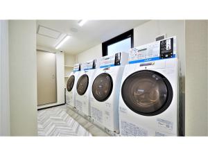 - une rangée de lave-linge blancs dans une buanderie dans l'établissement Y's Inn Naha Oroku Ekimae - Vacation STAY 25857v, à Naha