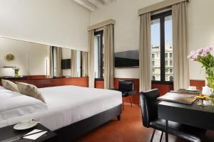 Habitación de hotel con cama y escritorio con ordenador en Hotel L'Orologio Venezia - WTB Hotels, en Venecia
