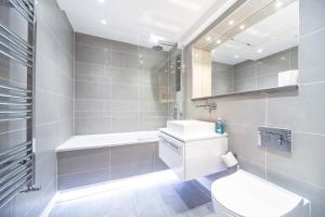 ein weißes Badezimmer mit Toilette und Waschbecken in der Unterkunft Palmer Apartments - Elephant & Castle in London + 37 Fotos