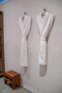 two white jackets are hanging on a wall at Casa Antonieta in Oaxaca City