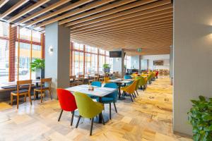 a dining room with tables and chairs and windows at Hotel Metropol in Warsaw