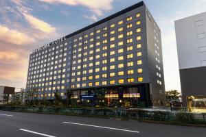 un edificio alto con muchas ventanas en una calle en Mercure Tokyo Haneda Airport, en Tokio