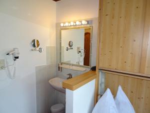 a bathroom with a sink and a mirror at Alpenhotel Landhaus Küchl in Kirchberg in Tirol