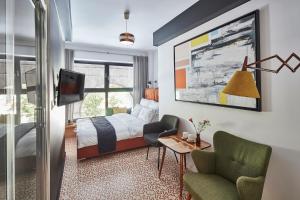 a bedroom with a bed and a tv and a chair at Bez Kantów Art Rooms in Warsaw