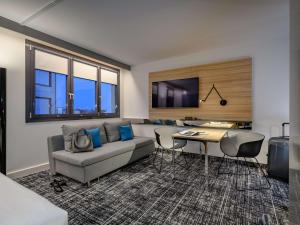 a living room with a couch and a table at Novotel Suites Berlin City Potsdamer Platz in Berlin