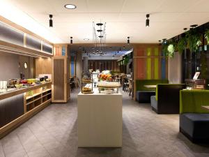 a restaurant with a counter with food on it at Novotel Suites Berlin City Potsdamer Platz in Berlin