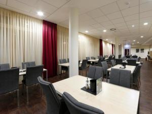 sala konferencyjna ze stołami, krzesłami i czerwonymi zasłonami w obiekcie B&B HOTEL Berlin-Mitte w Berlinie