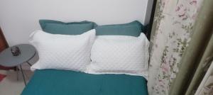 a bed with three pillows on it at Quarto plutão in Duque de Caxias