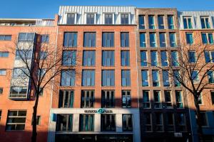 un grand bâtiment en brique avec un panneau d'alarme devant dans l'établissement Motel One Amsterdam-Waterlooplein, à Amsterdam