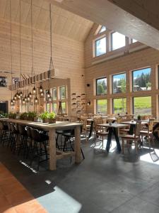 a dining room with tables and chairs and windows at Åsarna Skicenter in Åsarne