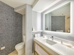 a bathroom with a sink and a toilet and a mirror at The Royal Sonesta Minneapolis Downtown in Minneapolis