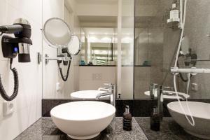 a bathroom with two sinks and a mirror at Motel One Berlin-Hauptbahnhof in Berlin +24 photos