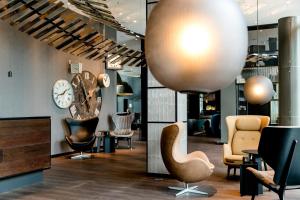 a lobby with chairs and a clock on the wall at Motel One Berlin-Hauptbahnhof in Berlin