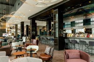 a restaurant with chairs and tables and a bar at Motel One Berlin-Hauptbahnhof in Berlin