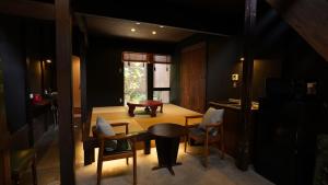 a room with a table and chairs and a window at Kaikoan in Kyoto