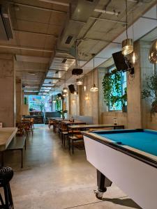 - un billard dans une salle avec des tables et des chaises dans l'établissement Wombat's City Hostel Munich Werksviertel, à Munich