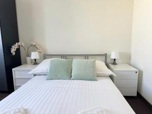 Hotel Mazowiecki WOW في وارسو: غرفة نوم بسرير ابيض مع مواقف ليلتين