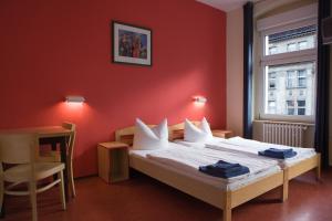 a bedroom with a bed with a red wall at acama Hotel & Hostel Kreuzberg in Berlin +37 photos