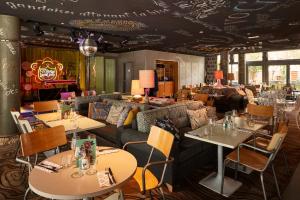 a restaurant with tables and couches and tables and chairs at Mama Shelter Lyon in Lyon
