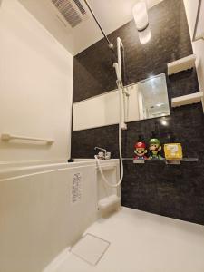 a bathroom with a black and white wall at 新宿区 新宿御苑前駅から歩いて5分 コンビニ1分 アパート全体を貸し出す民宿 in Tokyo
