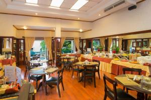 een restaurant met tafels en stoelen in een kamer bij Apartotel & Suites Villas del Rio in San José