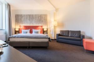a hotel room with a bed and a couch at Garner Hotel Berlin - Mitte by IHG in Berlin
