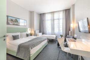 a hotel room with a bed and a desk at Garner Hotel Berlin - Checkpoint Charlie by IHG in Berlin +37 photos