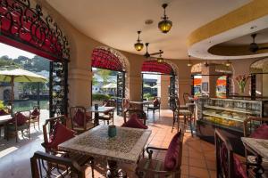 a restaurant with tables and chairs and windows at Casa del Rio Melaka in Malacca