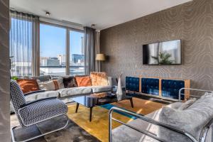 een woonkamer met banken en een tv bij H15 Boutique Hotel, Warsaw, a Member of Design Hotels in Warschau