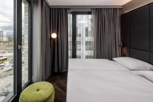 a hotel room with a bed and a large window at Hotel ROMY by AMANO in Berlin