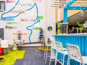 a room with chairs and a wall with a map at Ibis Styles Toulouse Labège in Labège