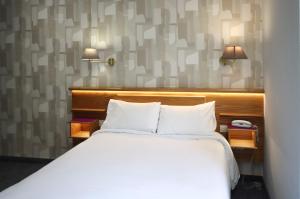 Кровать или кровати в номере Hôtel Le Lons