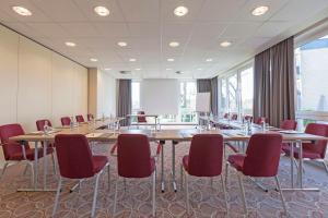 a conference room with long tables and red chairs at Best Western Premier Alsterkrug Hotel in Hamburg