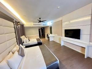 a living room with a couch and a flat screen tv at The Sterling Boutique Hotel Melaka in Malacca