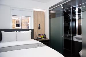 a bedroom with a bed and a bathroom with a shower at The Z Hotel Leicester Square in London