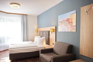 a hotel room with a bed and a chair at BlnCty Hotel in Berlin