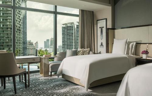 a bedroom with a large bed and a large window at Four Seasons Hotel Kuala Lumpur in Kuala Lumpur