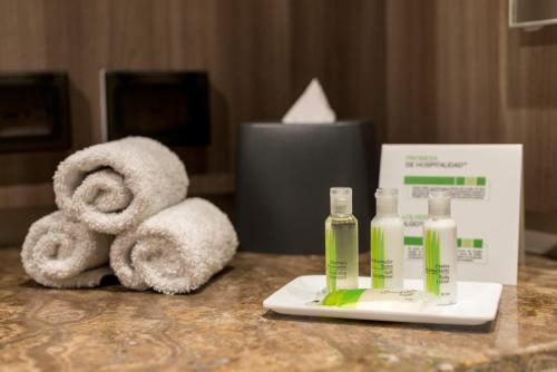 Holiday Inn - Lima Airport by IHG في ليما: كونتر غرفة مع المناشف وزجاجة من الصابون