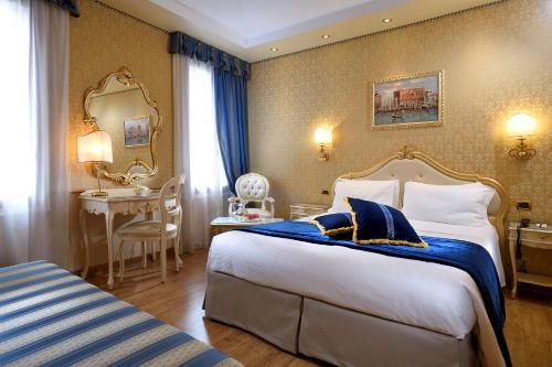 Una habitación de hotel con una cama grande y un escritorio. en Hotel Olimpia Venice, BW Signature Collection 3sup, en Venecia
