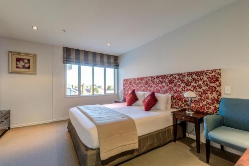 a hotel room with a bed and a chair at Parkview On Hagley in Christchurch