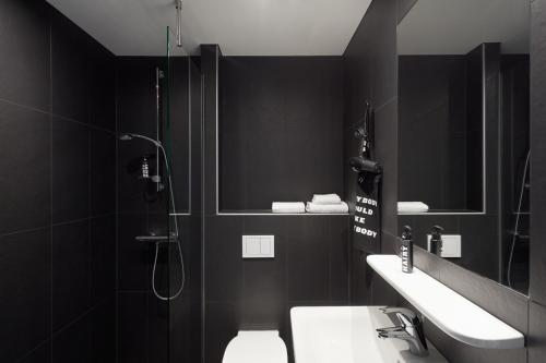 uma casa de banho com um chuveiro, um WC e um lavatório. em The Social Hub Berlin Alexanderplatz em Berlim