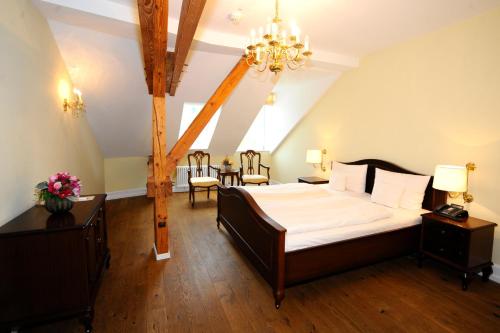 sypialnia z dużym łóżkiem i żyrandolem w obiekcie HELIOPARK Bad Hotel Zum Hirsch w Baden-Baden