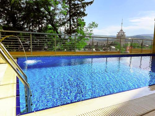 a large blue swimming pool with a fence around it at Hotel Residence Plaza in Tbilisi City