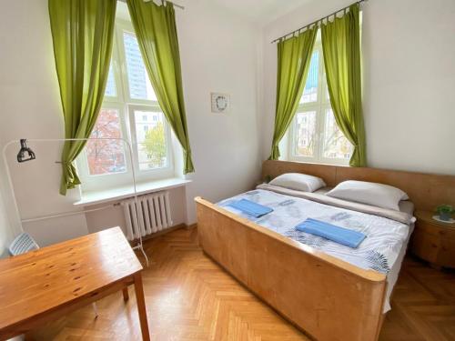 sypialnia z dużym łóżkiem z zielonymi zasłonami w obiekcie Oliwka Hostel w Warszawie
